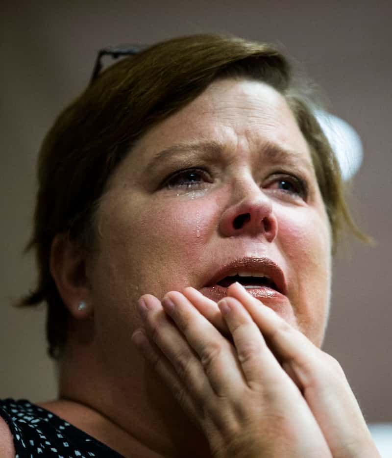 Michele Pettigrew sheds tears as she listens to an interfaith prayer service in a...