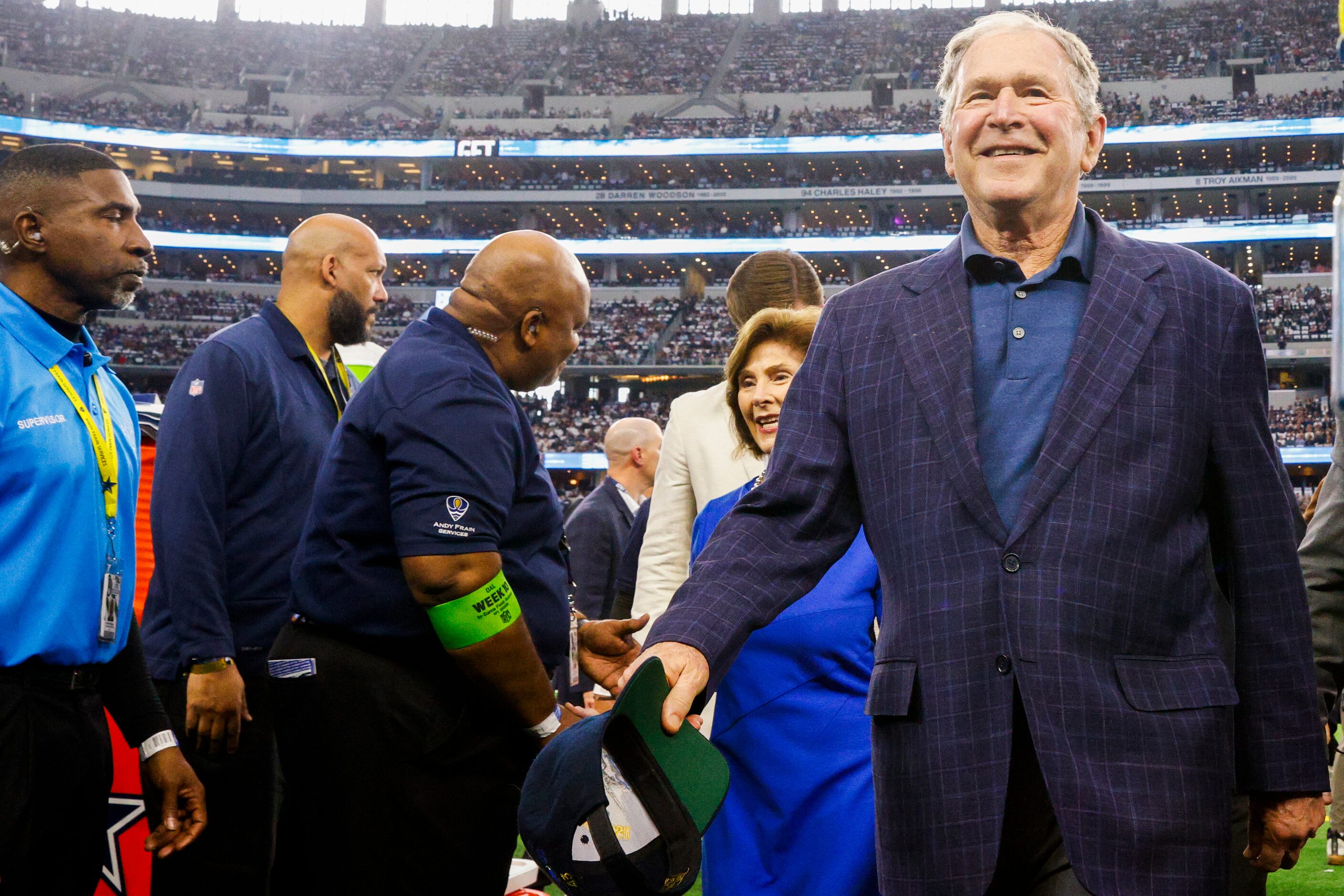 Former President George W. Bush walks off the field alongside Laura Bush after performing...