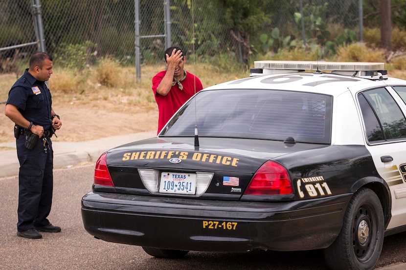 El Cenizo Police Chief Edgar Garcia (left) joins a Webb County Sheriff's deputy as they ask...