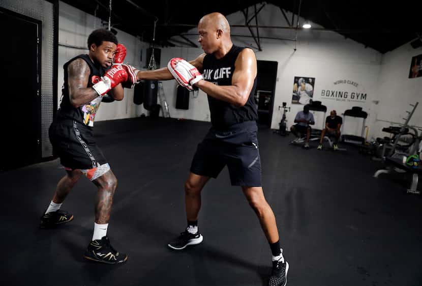 Trainer Derrick James (right) spars with professional boxer Errol Spence Jr. at his Dallas...