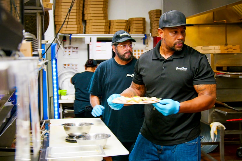 Paul Damico, the former president and CEO of Round Table Pizza, works with store manager...