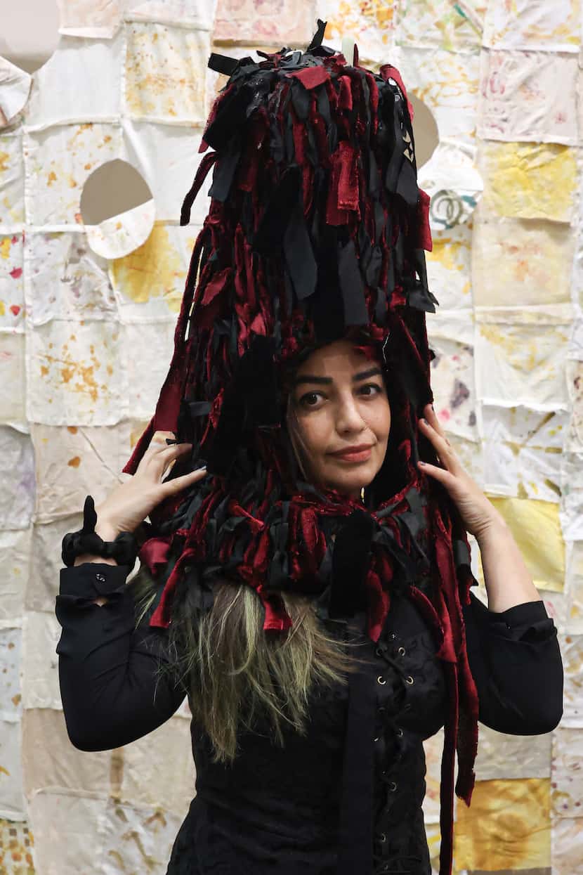 Artist Maryam Takalou wears her piece “Beyond the Nets, a head cover made in the likeness of...