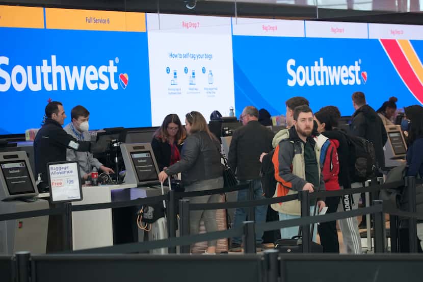 Travelers queue up at the check-in counters for Southwest Airlines in Denver International...