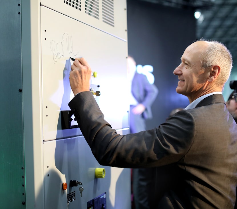 Siemens global CEO Roland Busch signs a ceremonial product in Fort Worth Friday.