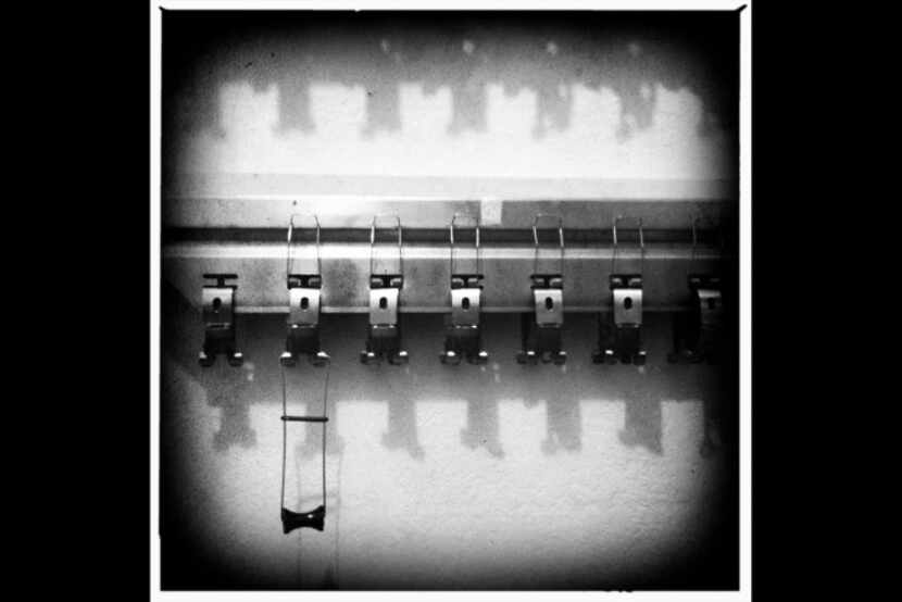 Film holders for one of the processors hang in a darkroom at The Color Lab. For 42 years as...
