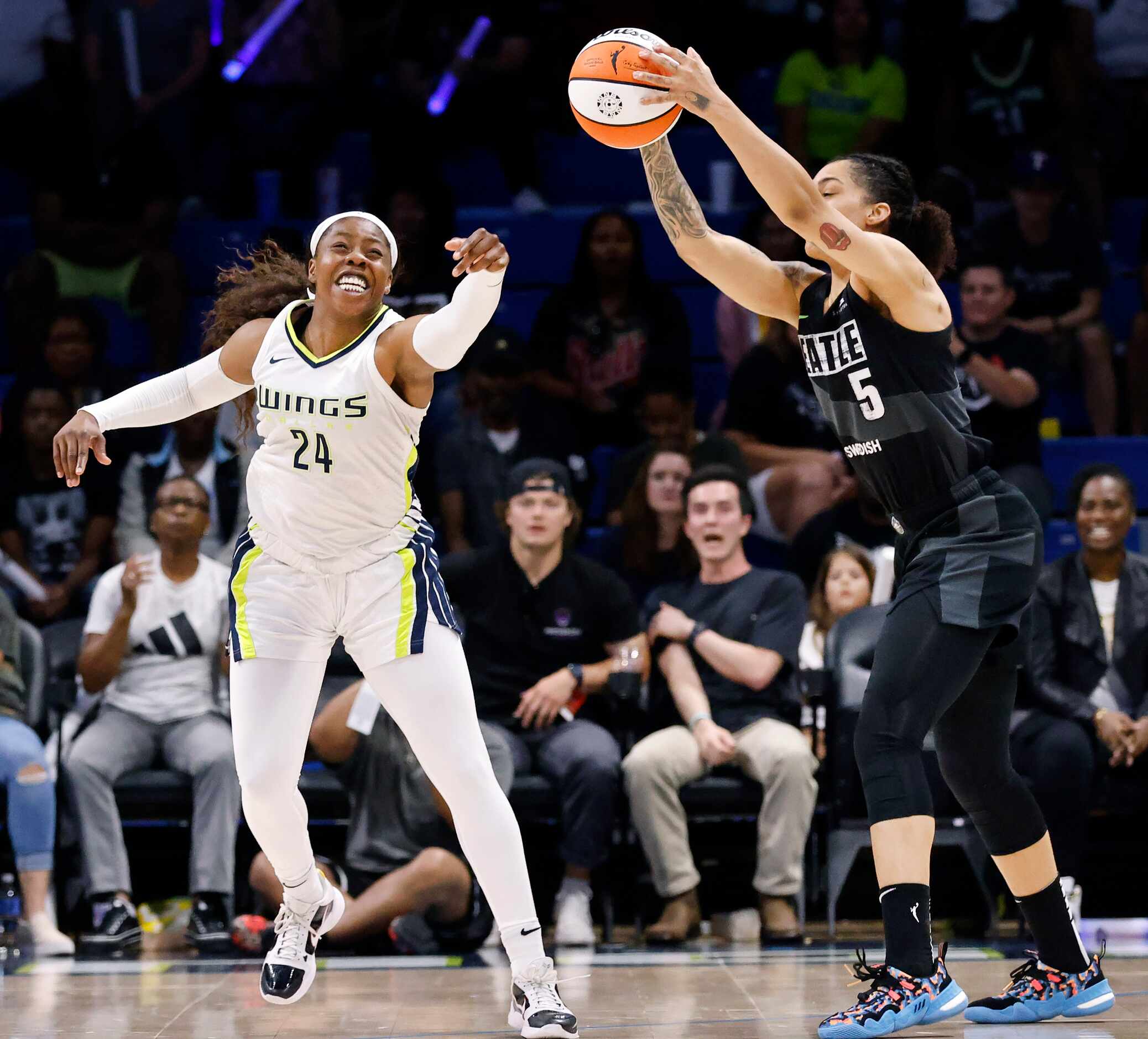 Dallas Wings guard Arike Ogunbowale (24) reaches in vein for a steal from Seattle Storm...