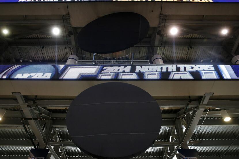 An AT&T (bottom) and Miller Lite corporate logos are covered in black cloth for the NCAA...