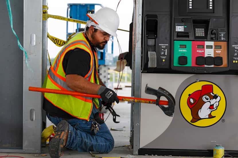 Johnny Heredia II  works on wiring inside a gas pump at the Buc-ee’s site in Terrell.