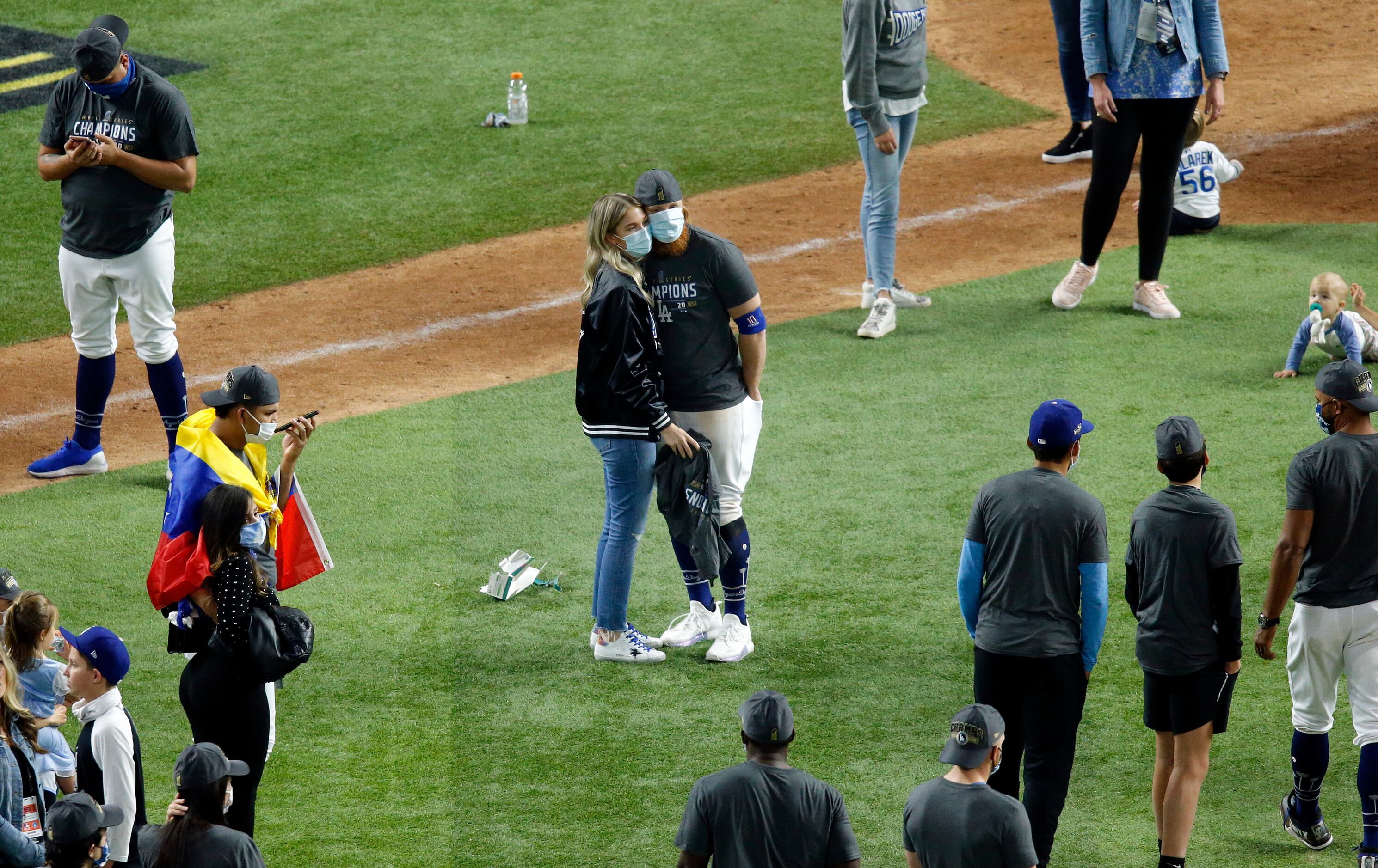 Los Angeles Dodgers third baseman Justin Turner and his wife Kourtney Pogue hug on the field...