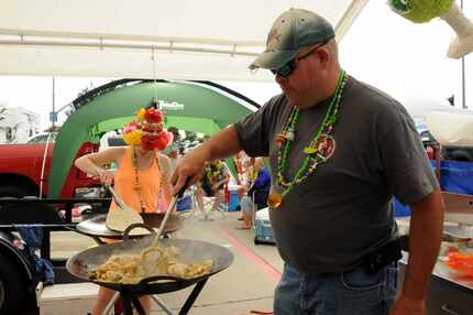 Walt Greenwade grills chicken fajitas at the Jimmy Buffett tailgate party at Toyota Stadium...