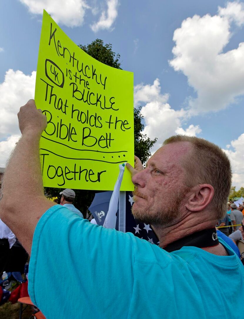  Reflecting the divide, same-sex marriage supporters gather to the left and Kim Davis...