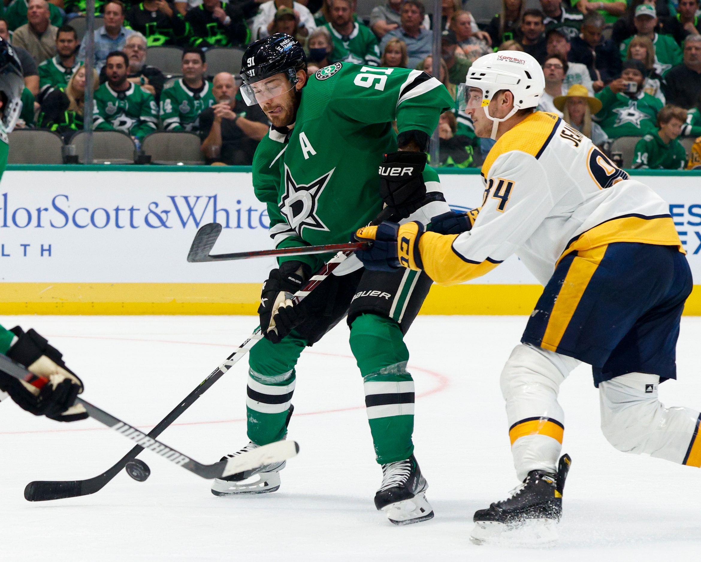 Dallas Stars center Tyler Seguin (91) passes the puck ahead of a defensing Nashville...