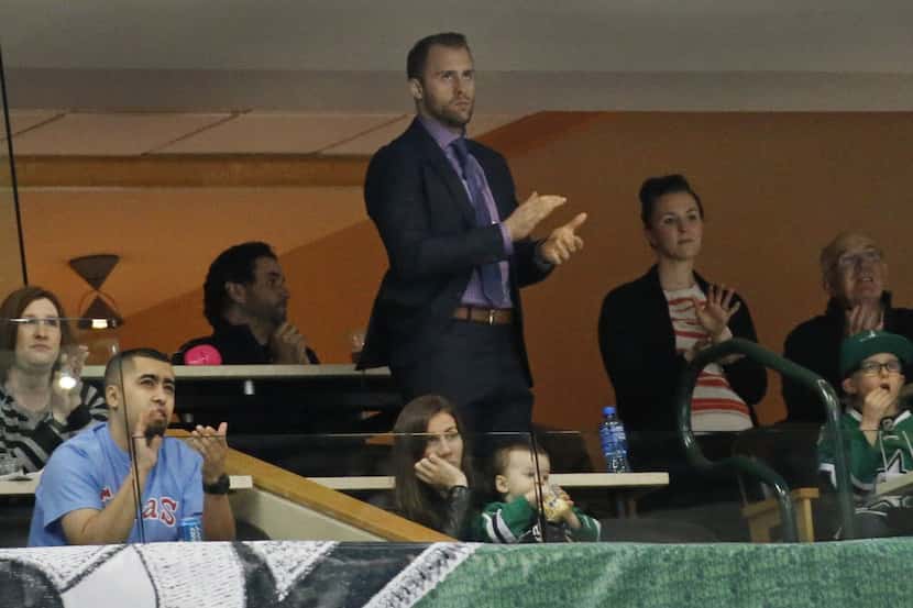 Dallas Stars fans applaud Rich Peverley, standing middle, during a first-period time out...