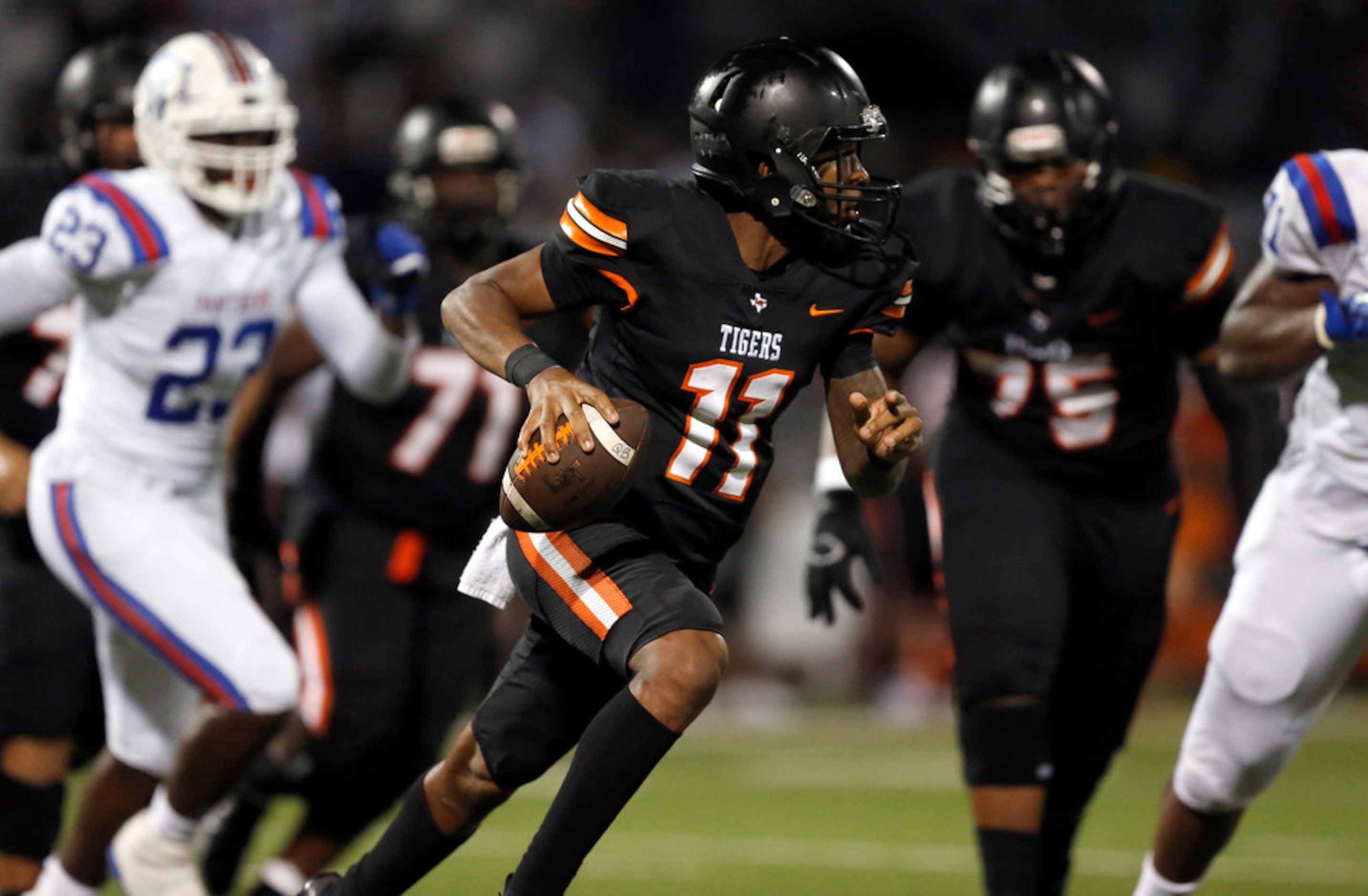 Lancaster quarterback James Mitchell (11) rolls out looking for a receiver against...