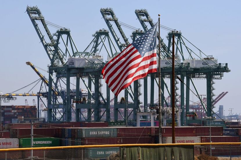 The U.S. flag flies over Chinese shipping containers unloaded at the Port of Long Beach on...