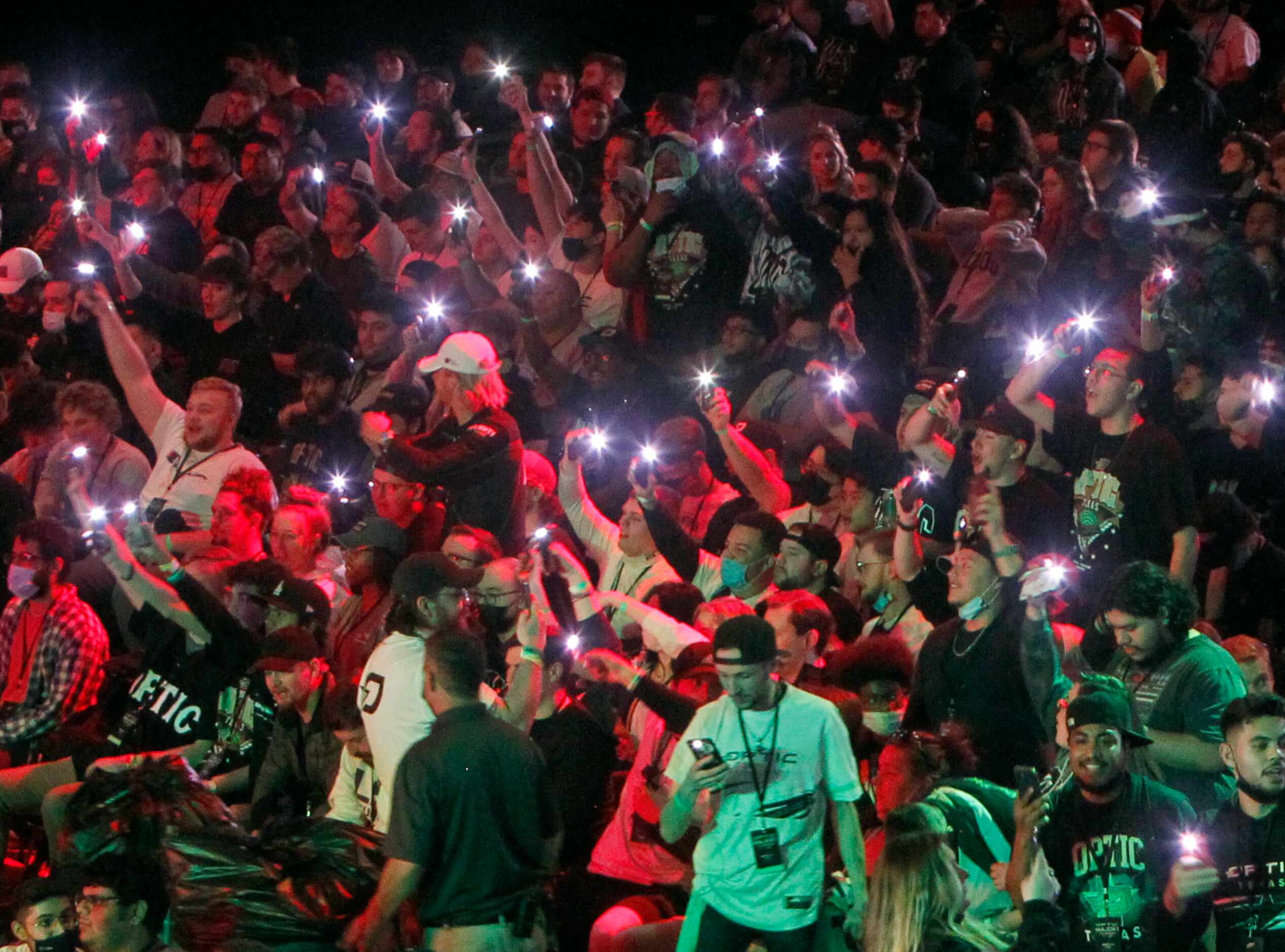 OpTic Texas fans use cellphone flashlights as they cheer before the start of the final...