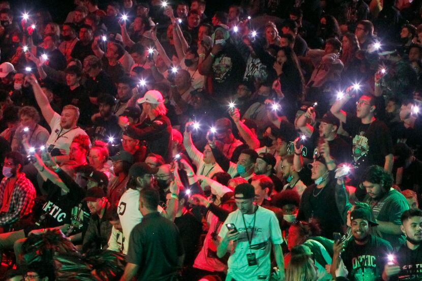 OpTic Texas fans use cellphone flashlights as they cheer before the start of the final...