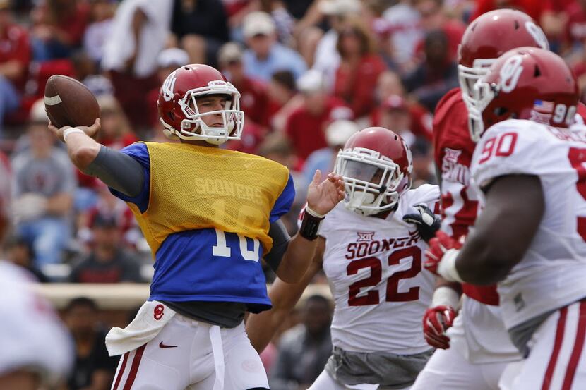 Oklahoma quarterback Austin Kendall, left, throws a pass during a spring NCAA college...