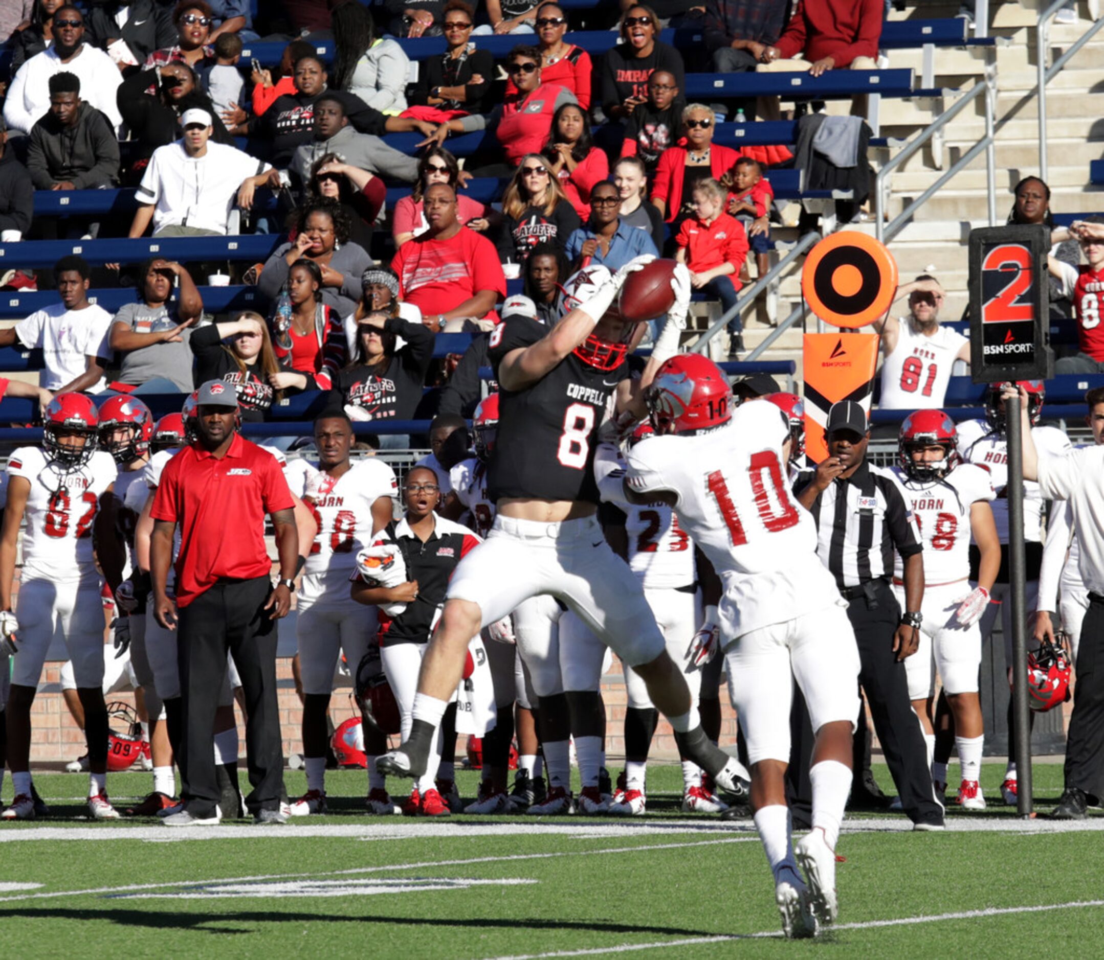 Coppell player 8, Blake Jackson, catches the ball as Horn defenseman 10, Larry Donnell,...