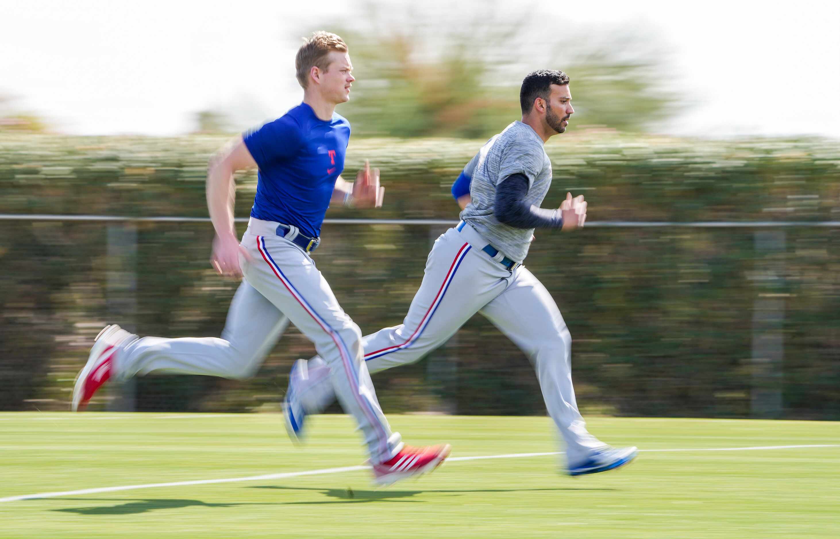 Texas Rangers pitcher Matt Bush (right) runs on a conditioning field with teammates after...