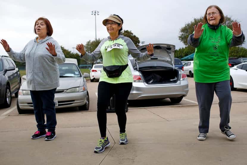 Bea Salazar, left, founder of Bea's Kids, Margaret Morales, and Susan Pence warm up with...