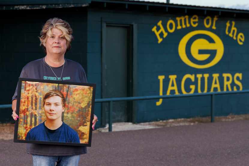 Mary Jane Erwin-McNiel holds a photo of her son, Rue McNiel, outside Jack Huey Field in...