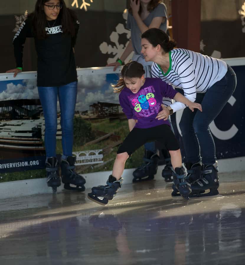 Jessica Pope helps her daughter, Kori Pope, learn how to ice skate at Panther Island Ice...