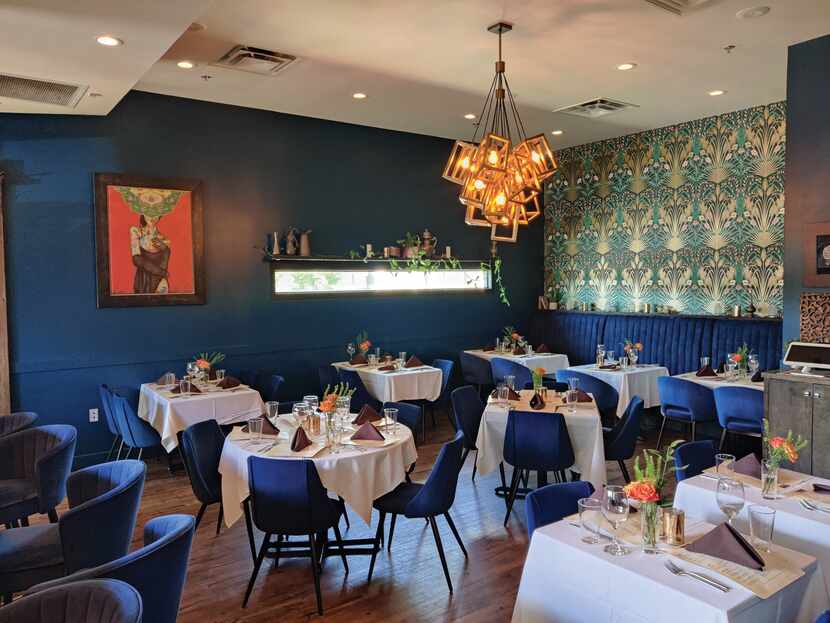 interior of fine dining restaurant with white table cloths and blue chairs