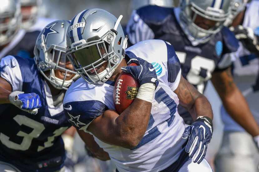 Dallas Cowboys running back Ezekiel Elliott avoids the defense as he rushes the ball during...