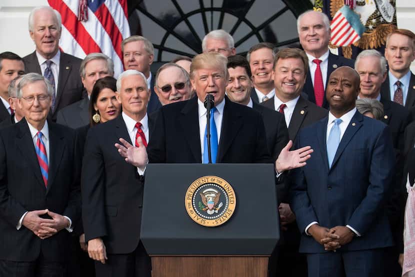 President Donald Trump celebrates the passage of the GOP tax plan with members of Congress. 