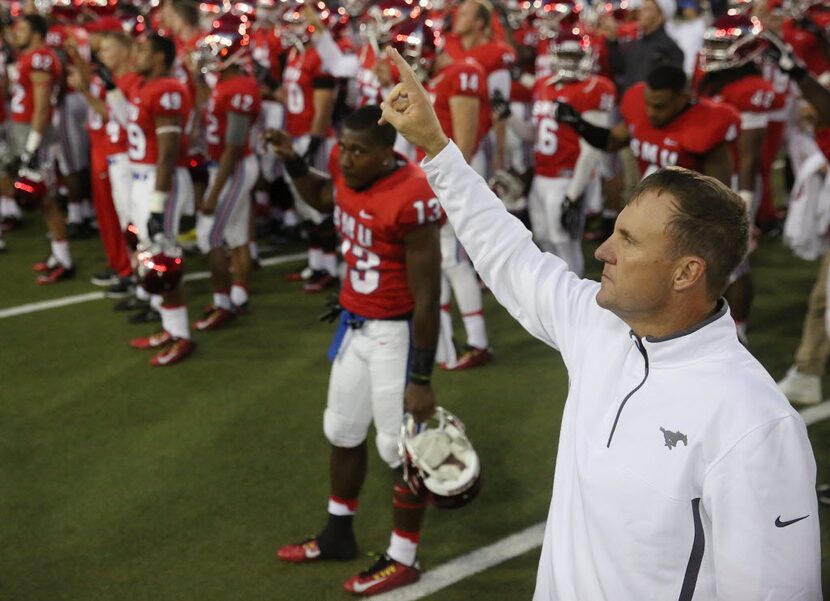 Southern Methodist Mustangs head coach Chad Morris joins his players for the school song...