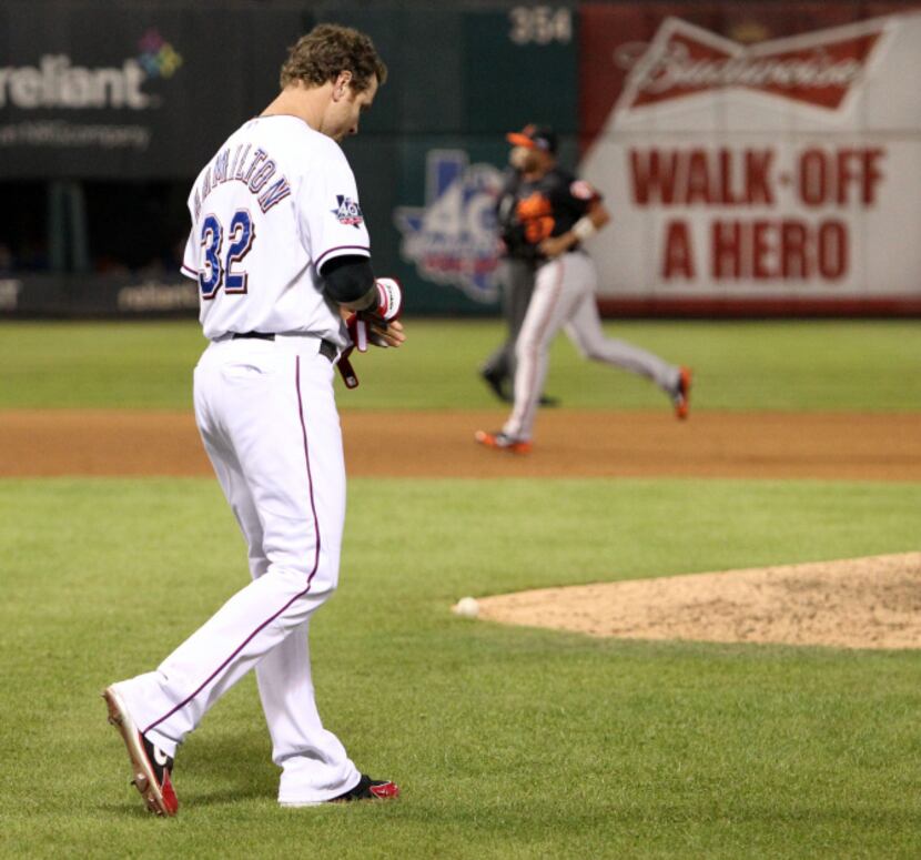 Texas left fielder Josh Hamilton walks out to his position after striking out to end the...