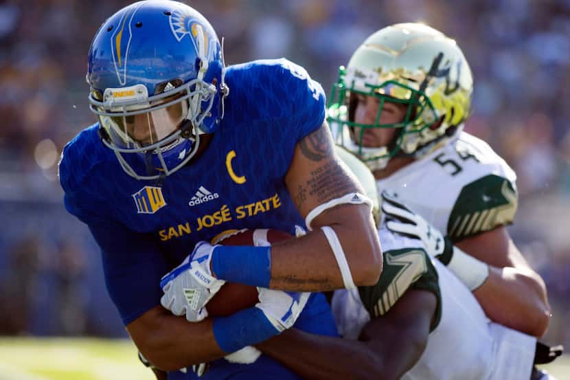 San Jose State wide receiver Justin Holmes, left, tries to wriggle out of the grasp of South...
