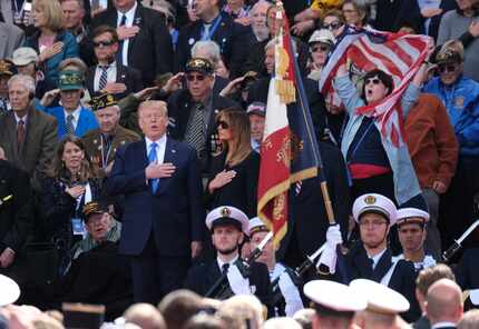President Donald Trump joins in in singing the national anthem as First Lady Melania Trump...