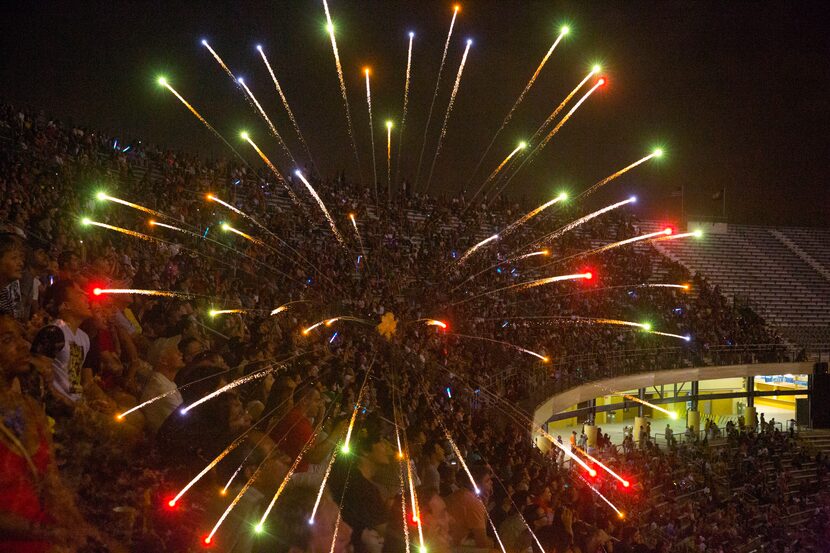 IN DOUBLE EXPOSURES ... Fireworks are seen double exposed over a crowd celebrating...