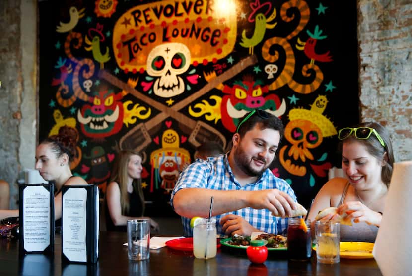 Diners at Revolver Taco Lounge's communal table (Vernon Bryant/The Dallas Morning News)