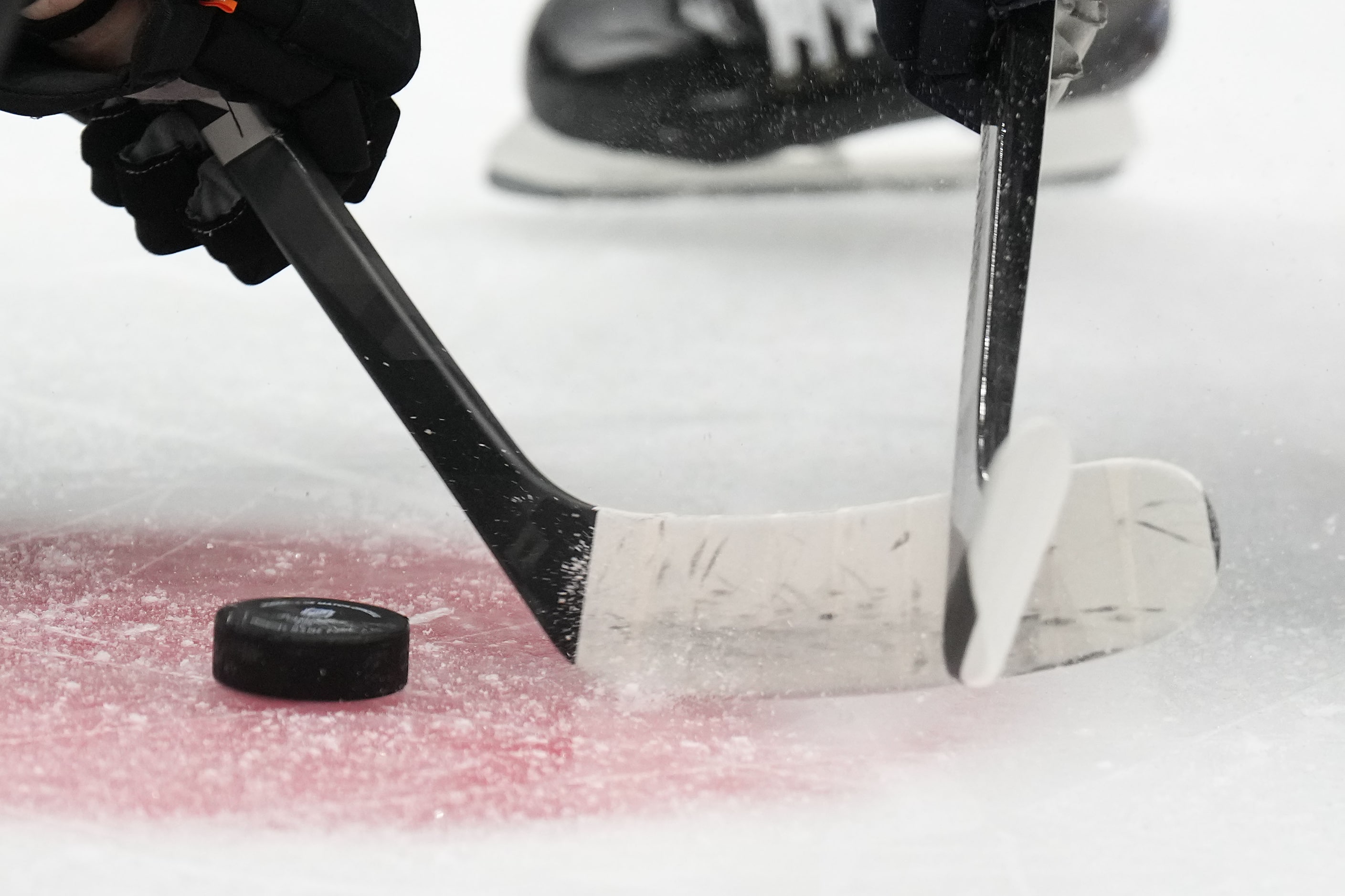 The puck drops on a face off during the first period of an NHL hockey game between the...