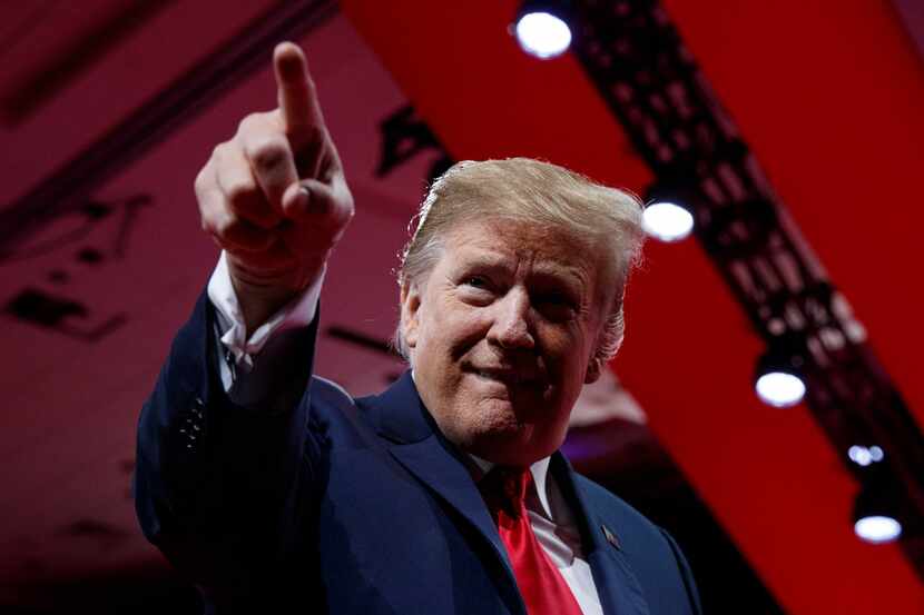 President Donald Trump points to the cheering audience as he arrives to speak at the annual...