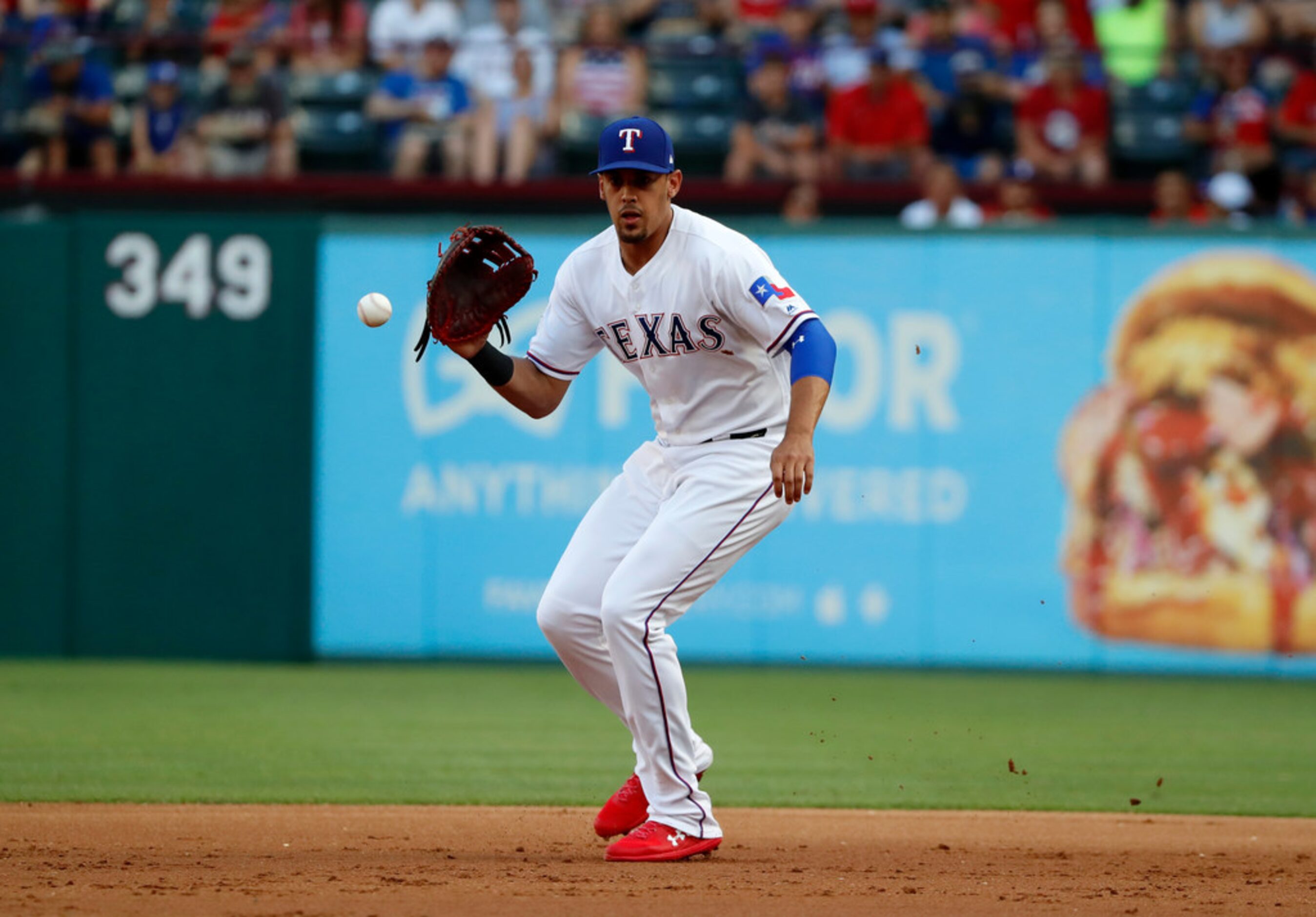 Texas Rangers' Ronald Guzman fields a ground out by Los Angeles Angels' Justin Bour in the...