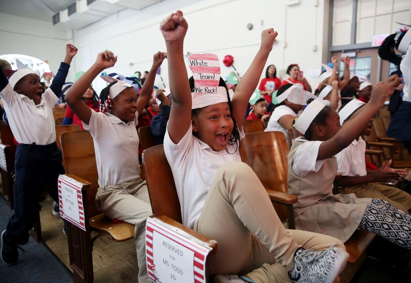 Second-grader Amari Hicks celebrates with her team after Mayor Mike Rawlings wins the green...