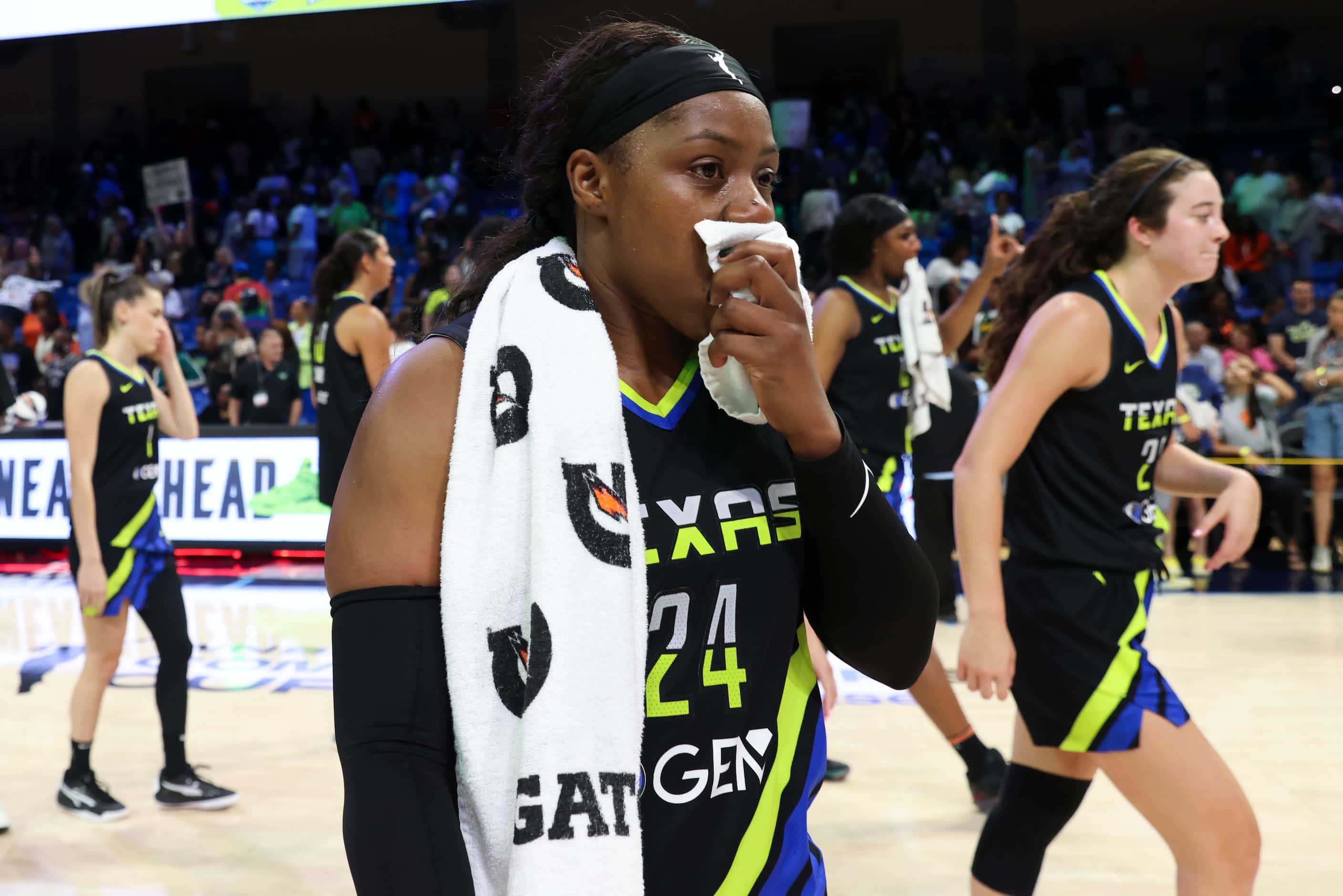 Dallas Wings guard Arike Ogunbowale (center) with her teammates exits the court after...