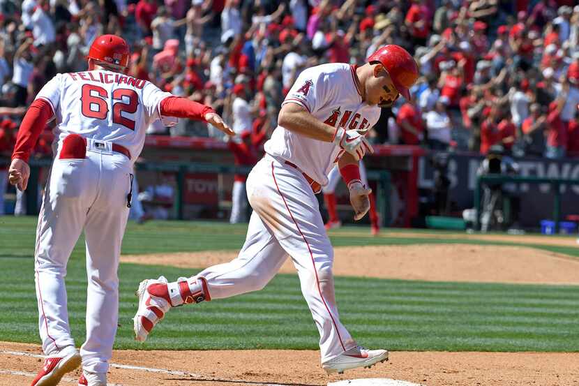 ANAHEIM, CA - APRIL 06: Mike Trout #27 is congratulated by Jesus Feliciano #62 of the Los...