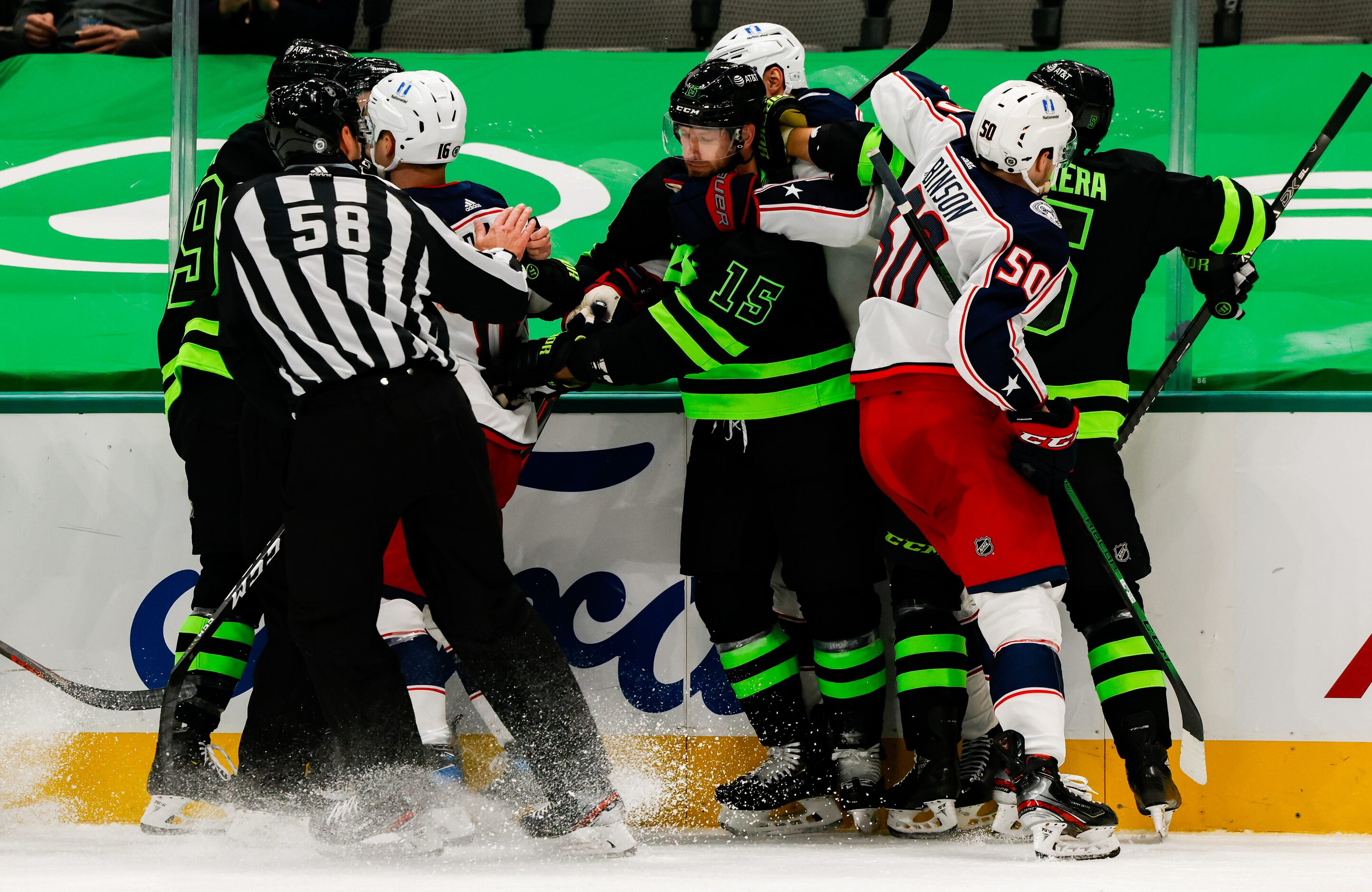 Linesman Ryan Gibbons (58) stops a fight between Dallas Stars and Columbus Blue Jackets...