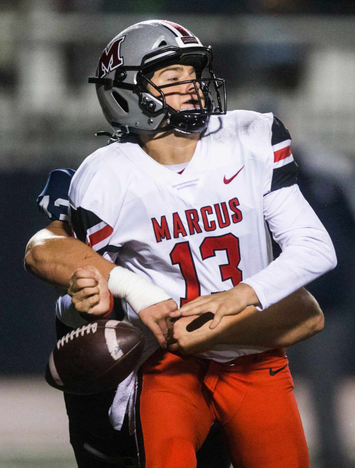 Flower Mound Marcus quarterback Garrett Nussmeier (13) loses the ball as he is sacked by...