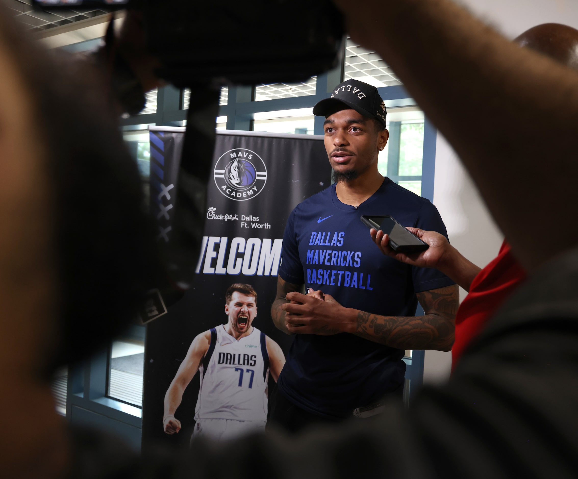 Dallas Mavericks forward and center PJ Washington listens to a question from a media member...