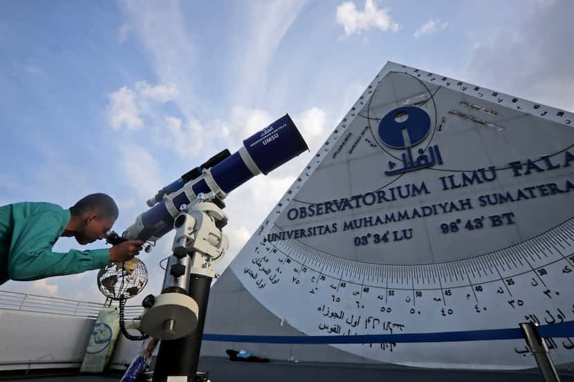 A member of staff uses a telescope to search the sky for the new moon that signals the start...