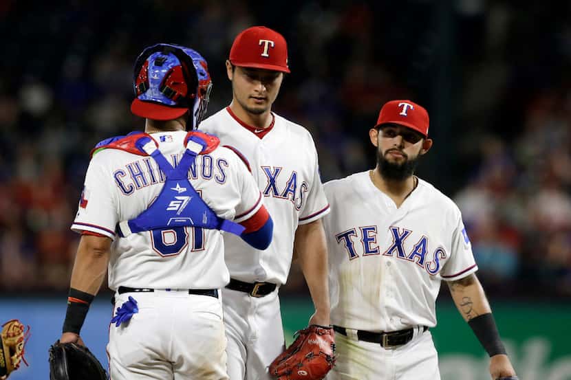 Texas Rangers catcher Robinson Chirinos (61) and teammate Rougned Odor, right, talk with Yu...