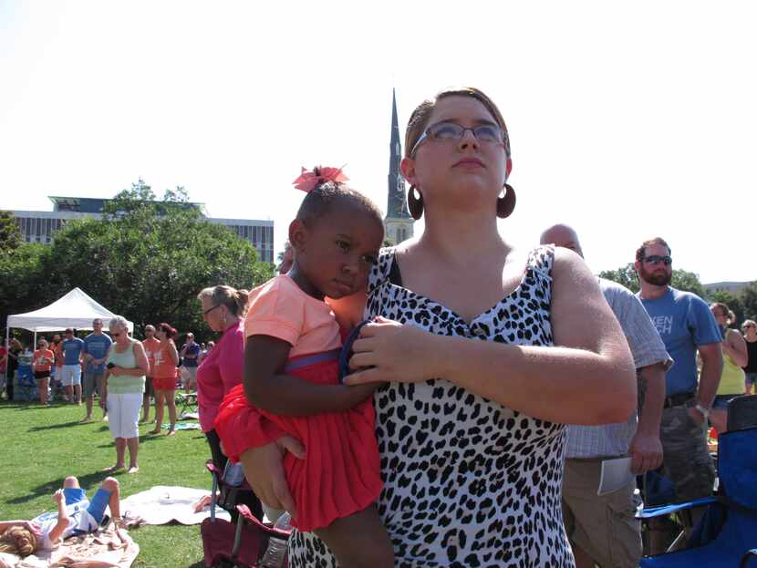 Quincy Williams holds her sister Michal as they listen to the bells chiming from St....