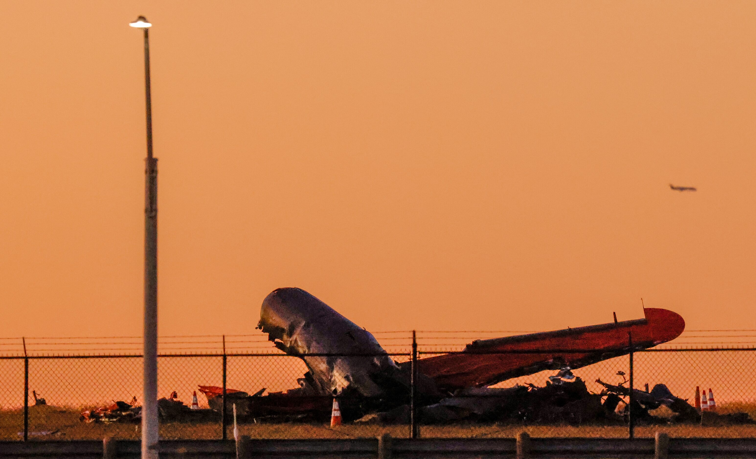 The sun begins to set over the damage from a mid-air collision between two planes that sits...