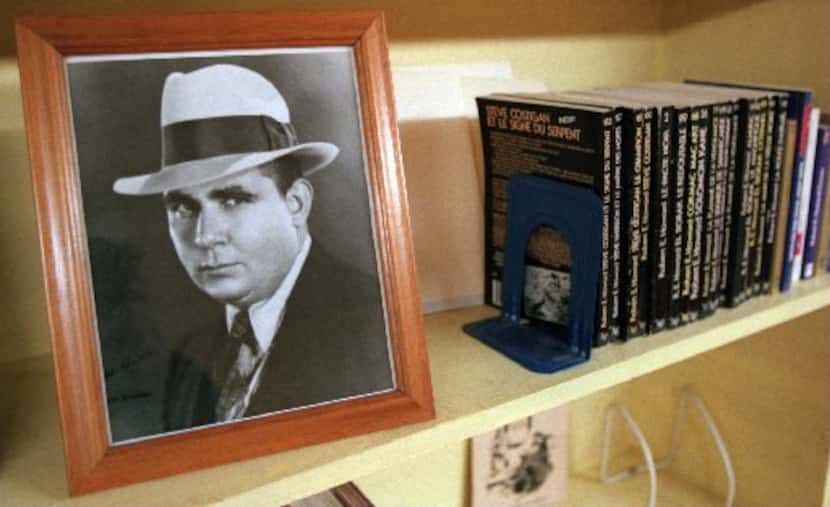 A picture of Robert  E. Howard sits on the shelf of the library along with some foreign...